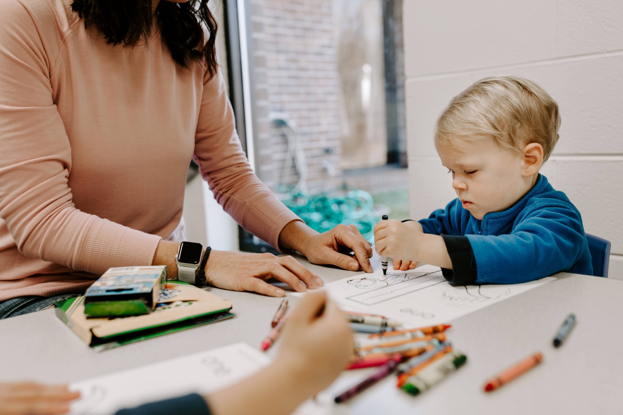 A young student coloring with crayons